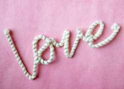 The word love spelled out using pipe cleaners and yarn